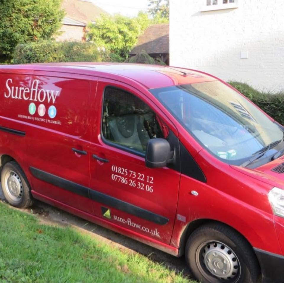 Sureflow’s red van parked on a driveway, showing 01825 73 22 12 and 07786 26 32 06 on the side